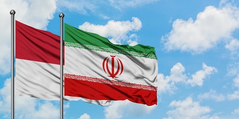 Iraq and Indonesia flag waving in the wind against white cloudy blue sky together. Diplomacy concept, international relations.