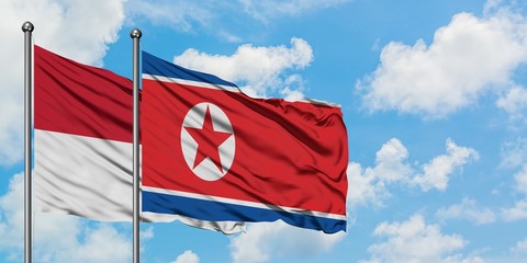 Iraq and North Korea flag waving in the wind against white cloudy blue sky together. Diplomacy concept, international relations.