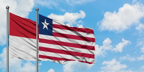 Iraq and Liberia flag waving in the wind against white cloudy blue sky together. Diplomacy concept, international relations.