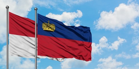 Iraq and Liechtenstein flag waving in the wind against white cloudy blue sky together. Diplomacy concept, international relations.