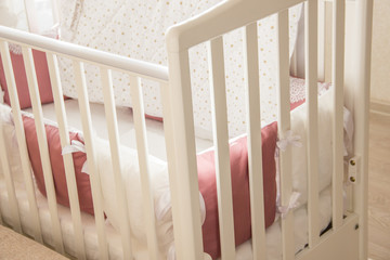 Naklejka na ściany i meble Baby bed crib with white and Burgundy color pillows with laces