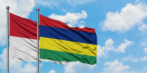 Iraq and Mauritius flag waving in the wind against white cloudy blue sky together. Diplomacy concept, international relations.