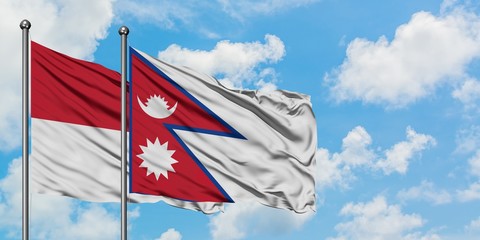 Iraq and Nepal flag waving in the wind against white cloudy blue sky together. Diplomacy concept, international relations.