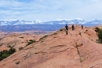 Fototapeta premium Son, mother and grandfather riding mountain bikes of singletrack in Moab, Utah