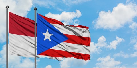 Iraq and Puerto Rico flag waving in the wind against white cloudy blue sky together. Diplomacy concept, international relations.