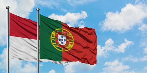 Iraq and Portugal flag waving in the wind against white cloudy blue sky together. Diplomacy concept, international relations.