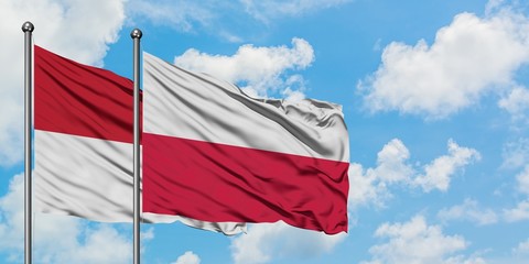 Iraq and Poland flag waving in the wind against white cloudy blue sky together. Diplomacy concept, international relations.