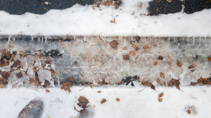 Tire tracks in the melting snow on asphalt road