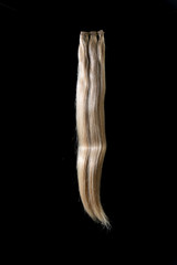 Hair extensions of various colors on a dark background.