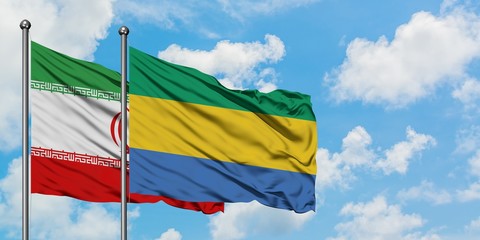 Iran and Gabon flag waving in the wind against white cloudy blue sky together. Diplomacy concept, international relations.