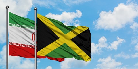 Iran and Jamaica flag waving in the wind against white cloudy blue sky together. Diplomacy concept, international relations.
