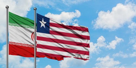 Iran and Liberia flag waving in the wind against white cloudy blue sky together. Diplomacy concept, international relations.