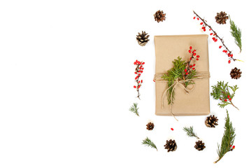 Kraft paper gift box with natural decor. Sprigs of pine and spruce as a background. Isolated on white top view.