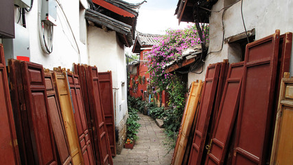 Fototapeta na wymiar Red doors on the side walk to the village in Lijiang Old town ,Yunnan, China.