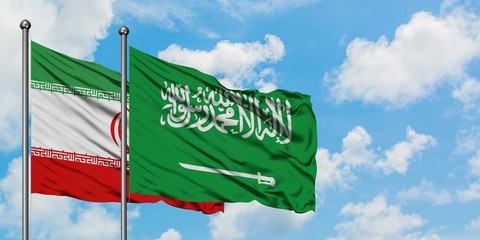 Iran and Saudi Arabia flag waving in the wind against white cloudy blue sky together. Diplomacy concept, international relations.