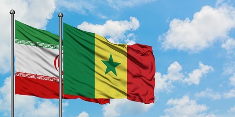 Iran and Senegal flag waving in the wind against white cloudy blue sky together. Diplomacy concept, international relations.