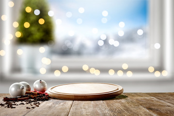 Table background of free space for your decoration and winter window background.Christmas tree.Winter landscape of mountains. Blurred lights.Copy space. 