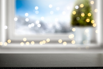 Table background of free space for your decoration and winter window background.Christmas tree.Winter landscape of mountains. Blurred lights.Copy space. 