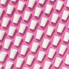 Pattern of empty paper disposable cups are laying on a background with hard shadows