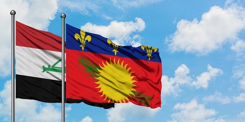 Iraq and Guadeloupe flag waving in the wind against white cloudy blue sky together. Diplomacy concept, international relations.