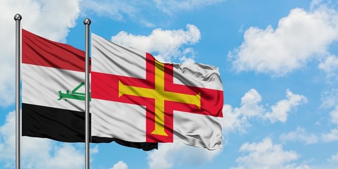 Iraq and Guernsey flag waving in the wind against white cloudy blue sky together. Diplomacy concept, international relations.