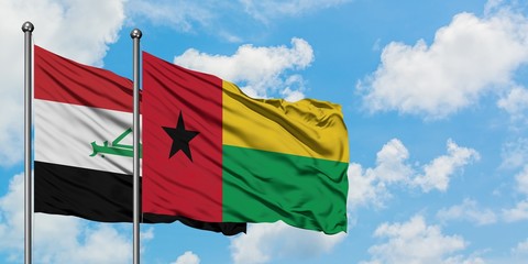 Iraq and Guinea Bissau flag waving in the wind against white cloudy blue sky together. Diplomacy concept, international relations.