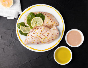 Chicken fillet with mustard and sauces on a black background. Proper nutrition. On a gray background. Diet meat