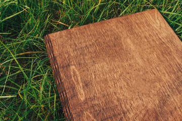Wooden photobook on green grass