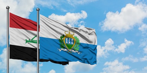 Iraq and San Marino flag waving in the wind against white cloudy blue sky together. Diplomacy concept, international relations.