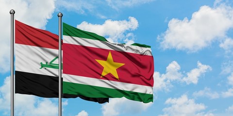Iraq and Suriname flag waving in the wind against white cloudy blue sky together. Diplomacy concept, international relations.