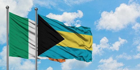 Ireland and Bahamas flag waving in the wind against white cloudy blue sky together. Diplomacy concept, international relations.