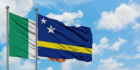 Ireland and Curacao flag waving in the wind against white cloudy blue sky together. Diplomacy concept, international relations.