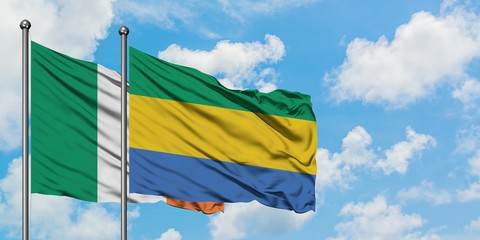 Ireland and Gabon flag waving in the wind against white cloudy blue sky together. Diplomacy...