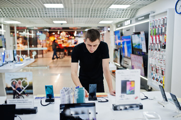 Seller man mobile phone professional consultant in tech store or shop.