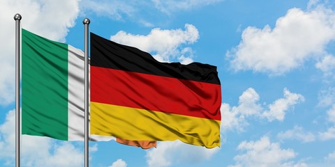 Ireland and Germany flag waving in the wind against white cloudy blue sky together. Diplomacy concept, international relations.