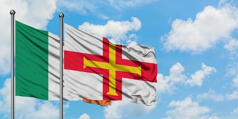 Ireland and Guernsey flag waving in the wind against white cloudy blue sky together. Diplomacy concept, international relations.