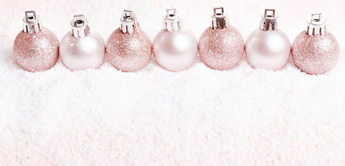 Christmas composition. pink and silver christmas balls on snow white background.