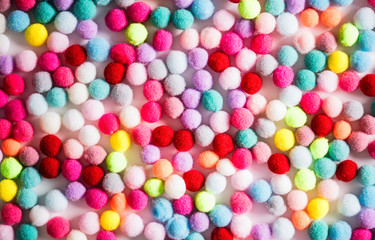 Fototapeta na wymiar Texture of small colorful textile fluffy pompons on a white background. Flat lay. Creative.