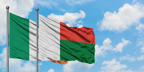 Ireland and Madagascar flag waving in the wind against white cloudy blue sky together. Diplomacy concept, international relations.