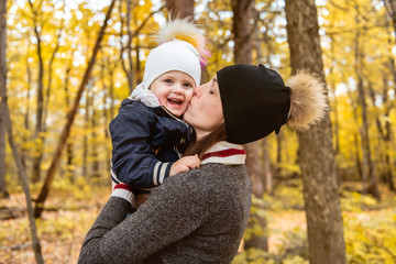 A portrait of a mother with child in the autumn park