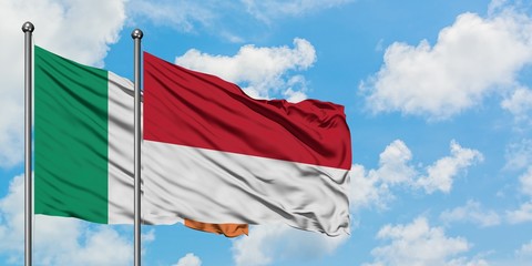 Ireland and Monaco flag waving in the wind against white cloudy blue sky together. Diplomacy concept, international relations.