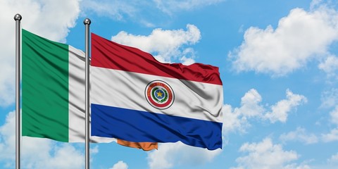 Ireland and Paraguay flag waving in the wind against white cloudy blue sky together. Diplomacy concept, international relations.