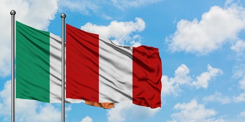 Ireland and Peru flag waving in the wind against white cloudy blue sky together. Diplomacy concept, international relations.