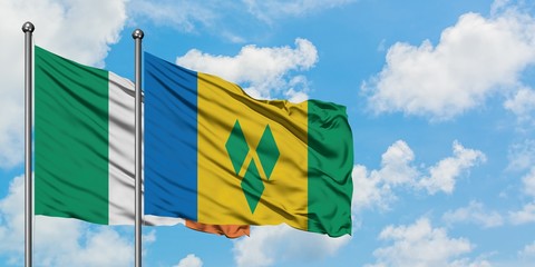 Ireland and Saint Vincent And The Grenadines flag waving in the wind against white cloudy blue sky together. Diplomacy concept, international relations.