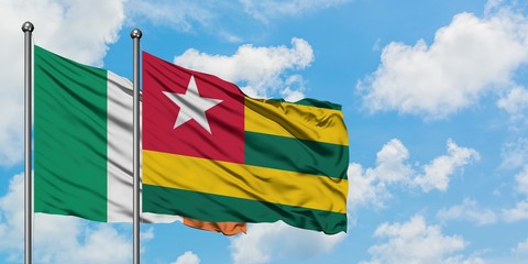 Ireland and Togo flag waving in the wind against white cloudy blue sky together. Diplomacy concept, international relations.