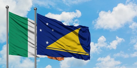 Ireland and Tokelau flag waving in the wind against white cloudy blue sky together. Diplomacy concept, international relations.