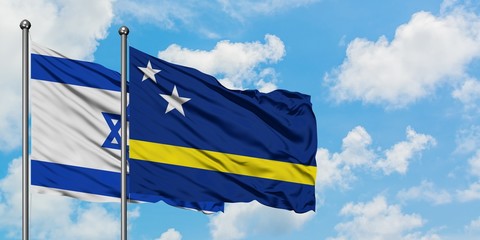 Israel and Curacao flag waving in the wind against white cloudy blue sky together. Diplomacy concept, international relations.