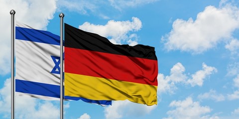 Israel and Germany flag waving in the wind against white cloudy blue sky together. Diplomacy concept, international relations.