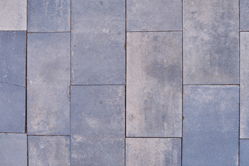 Old street tiles in grey, background close-up