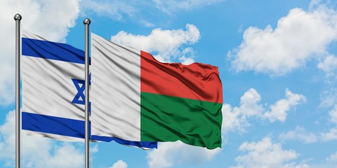 Israel and Madagascar flag waving in the wind against white cloudy blue sky together. Diplomacy concept, international relations.